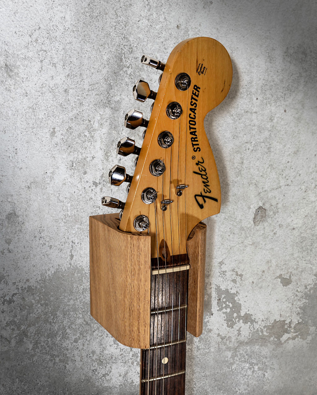 Hanger de madera para guitarra instalado en pared con guitarra eléctrica
