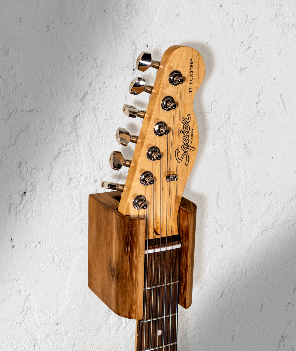 Hanger de madera para guitarra instalado en pared con guitarra eléctrica
