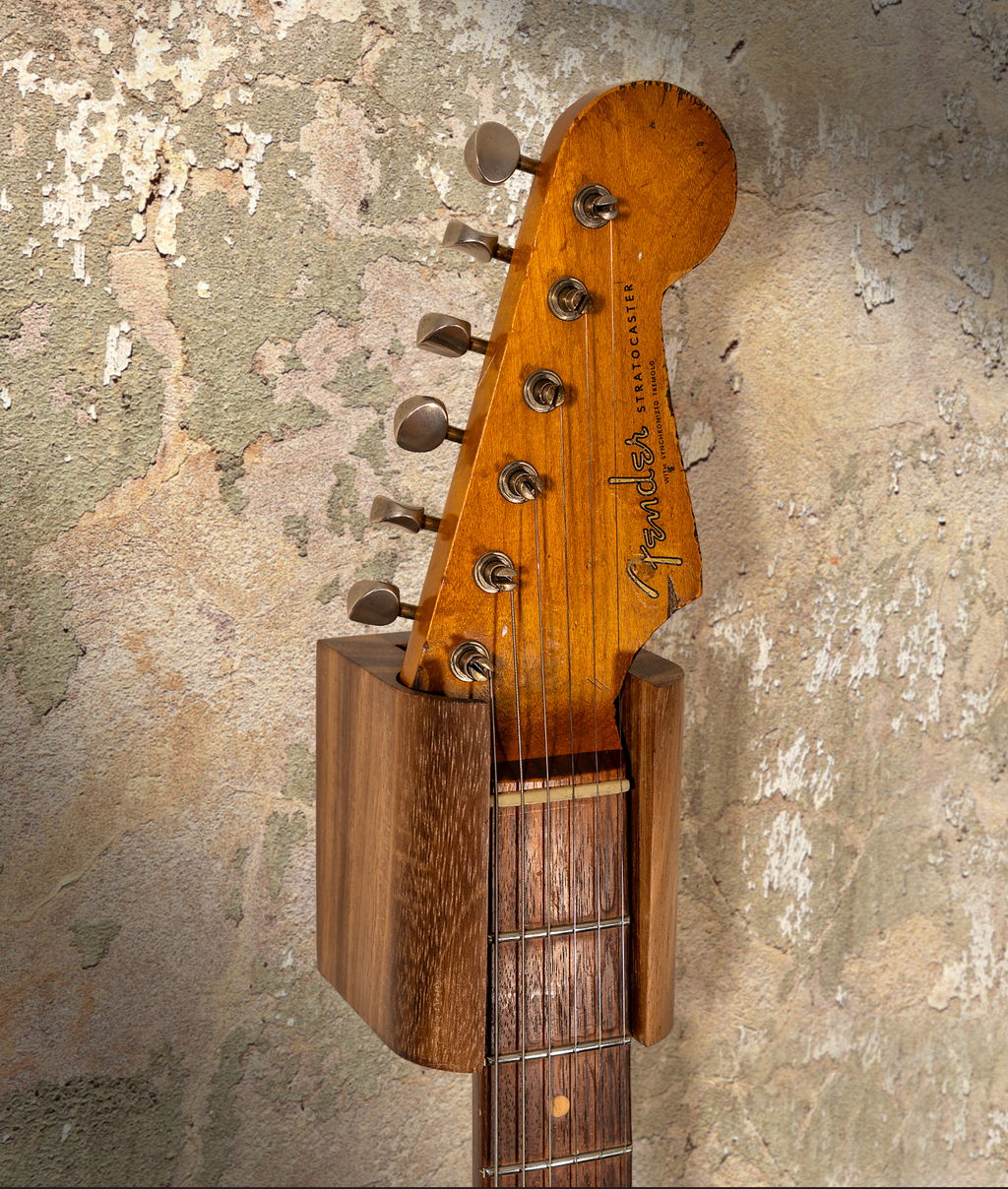 Hanger de madera para guitarra instalado en pared con guitarra eléctrica
